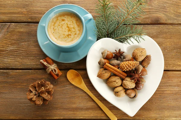 Taza de café y especias en plato en forma de corazón sobre fondo de madera — Foto de Stock