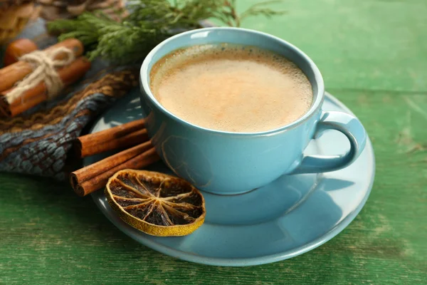 Kopje koffie met zoete specerijen op servet op groene houten achtergrond — Stockfoto