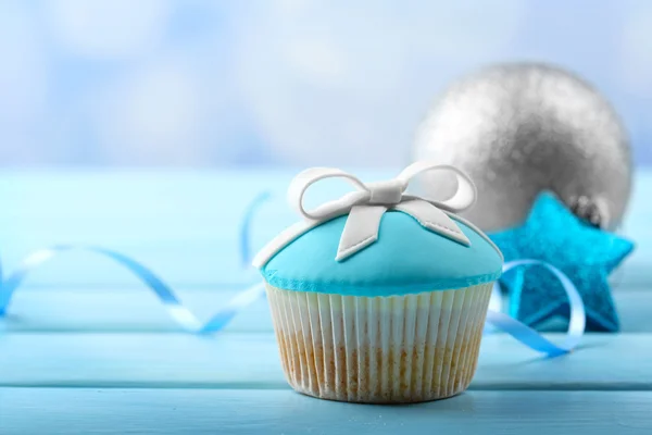 Gâteau savoureux avec arc et jouets de Noël sur fond en bois de couleur — Photo