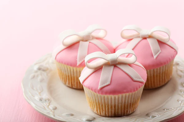 Νόστιμο cupcakes με τόξο σε ξύλινα φόντο χρώμα — Φωτογραφία Αρχείου