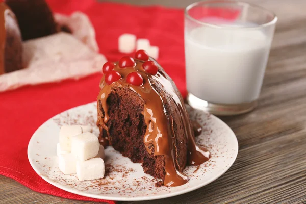 Pedazo de pastel de chocolate con bayas de árbol de nieve en una mesa — Foto de Stock