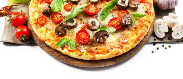 Pizza saborosa e legumes frescos na tábua de madeira redonda, close-up — Fotografia de Stock
