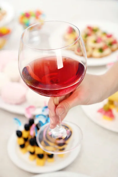 Donna in possesso di bicchiere da vino su sfondo buffet — Foto Stock