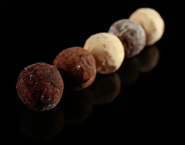 Verschiedene Schokoladenbonbons auf schwarzem Hintergrund — Stockfoto