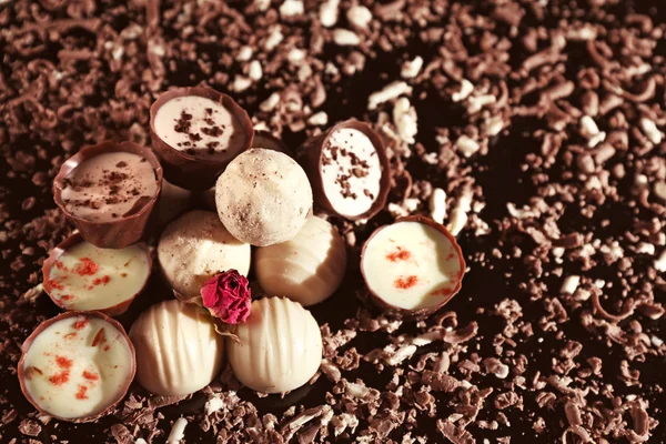 Różne cukierki czekoladowe z płatków na czarnym tle — Zdjęcie stockowe