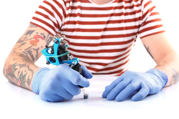 Tatueraren händer i handskar med tatuering maskin — Stockfoto