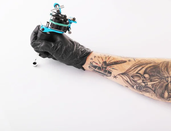 Hand in de handschoen met tattoo machine — Stockfoto