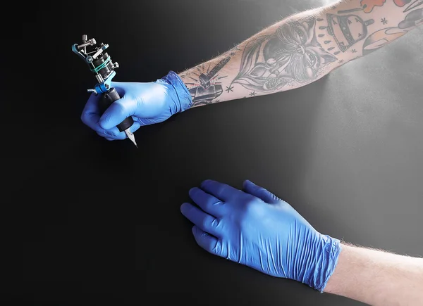 Mano tattooista in guanto medico — Foto Stock