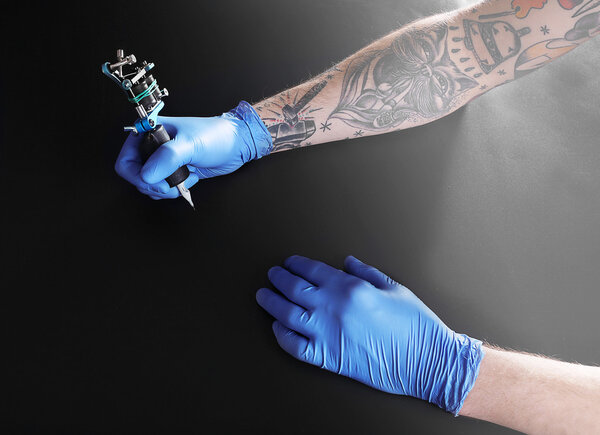Tattooist hand in medical glove