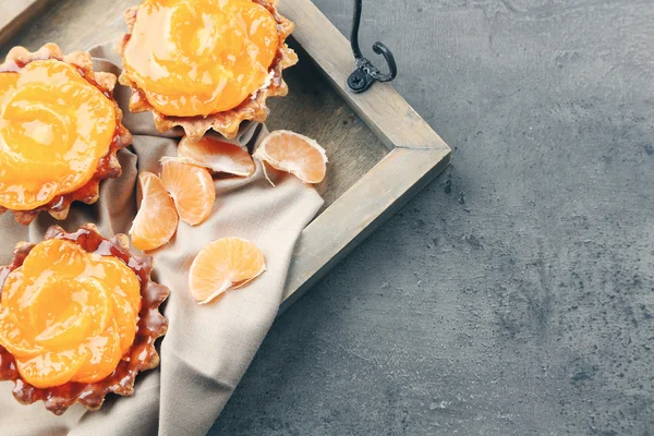 Sladké koláče s mandarinkami na tmavě kovový stůl, zblízka — Stock fotografie