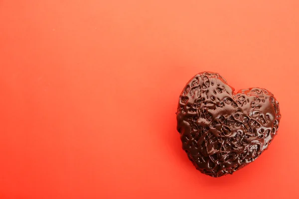 Coeur chocolat sur fond rouge, gros plan — Photo