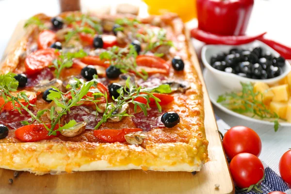 Rectangle délicieuse pizza et légumes sur la table — Photo