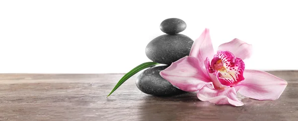 Wellness-Kiesel und schöne rosa Orchidee auf weißem Hintergrund — Stockfoto