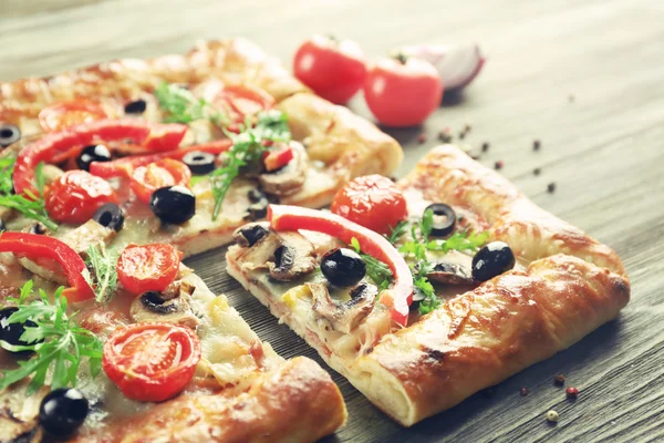 Świeżo domowej roboty pizze na drewnianym stole zbliżenie — Zdjęcie stockowe