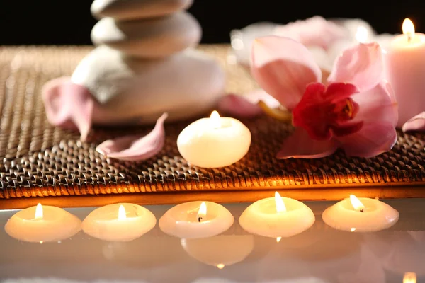 Spa bodegón con piedras, velas y flores en el agua de cerca — Foto de Stock