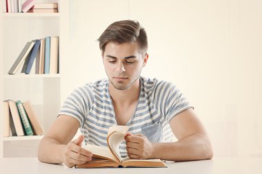 Genç adam masada kitap okumak