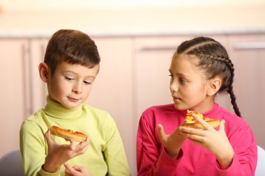 Çocuklar pizza yiyor.  