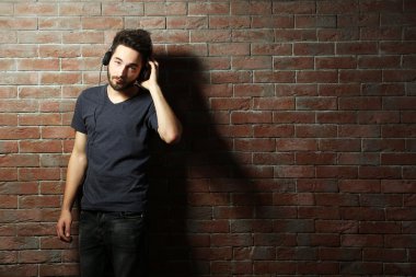 Kulaklıkla müzik dinleyen genç adam. 