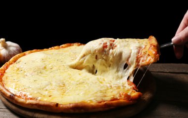 Lezzetli dilimlenmiş pizza üzerinde ahşap masa, yakın çekim