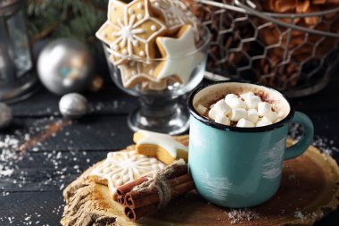 Hatmi ve siyah masada kurabiye ile sıcak kakao bir fincan