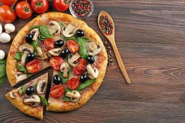 Sebze ile lezzetli lezzetli pizza ahşap masanın üzerine dilimlenmiş