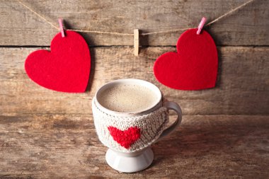 Kahve fincanı süt ve ahşap arka plan üzerinde iki kalp