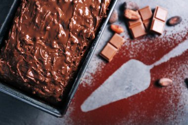 Lezzetli pasta çikolata ve kakao gri arka plan üzerinde ile dekore edilmiş tavada yakın çekim