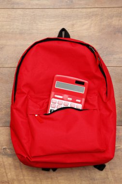 kırmızı sırt çantası ve hesap makinesi 