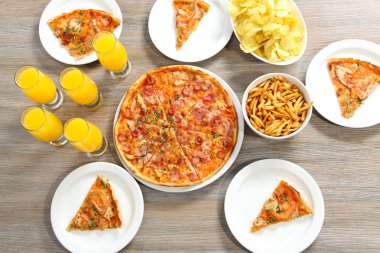 Evde pizza ve içecekler için arkadaşları ile tablo