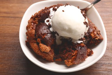 Çikolata lav kek ahşap masa üzerinde bir kase dondurma ile