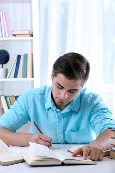 Joven leyendo libro en la mesa — Foto de Stock