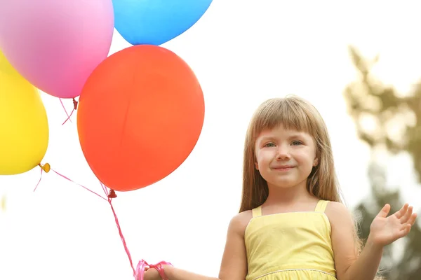 Liten flicka med ballonger — Stockfoto