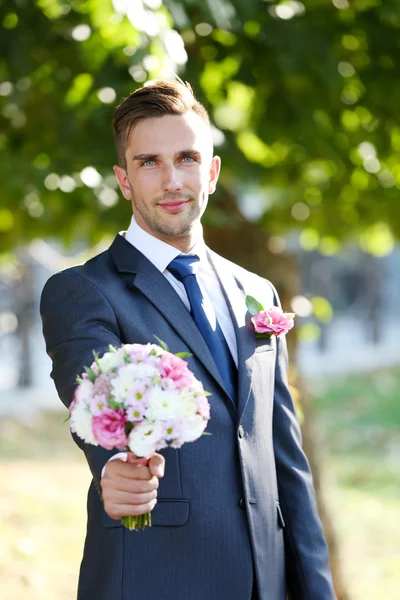 Groom holding wedding bouquet — Stock Photo, Image