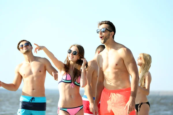 Happy couple and friends relaxing at beach — Stock Photo, Image