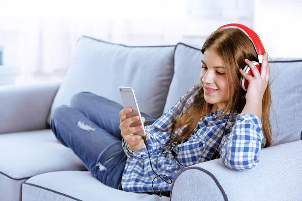 Красивая девушка слушает музыку на диване — стоковое фото