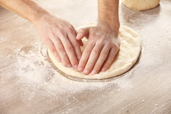 Hands preparing dough basis for pizza — Stock Photo, Image