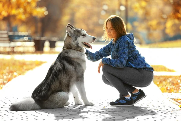 Frau geht mit Hund im Park spazieren — Stockfoto