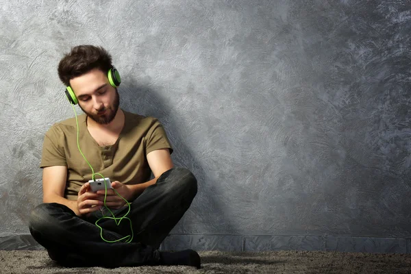 Joven escucha música con auriculares — Foto de Stock