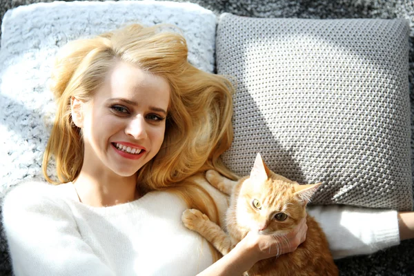 Woman laying with red cat — Stock Photo, Image