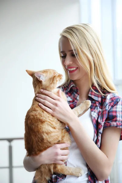 Jeune femme posant avec chat rouge — Photo