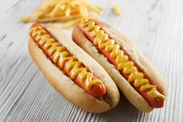 Perros calientes y queso sobre fondo de madera —  Fotos de Stock