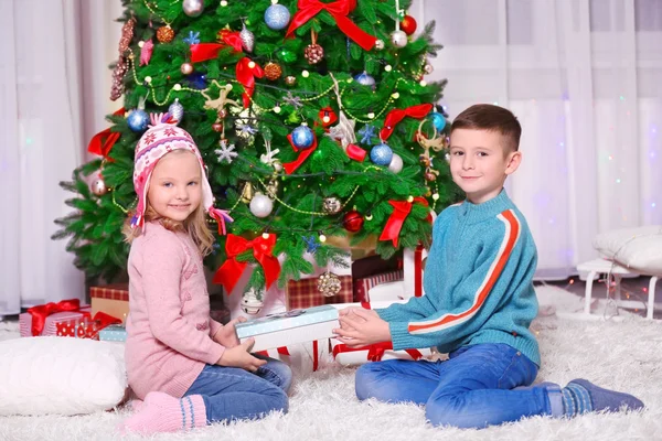 Happy children with gifts in Christmas room — Stock Photo, Image