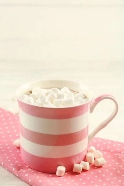 Mug of hot chocolate with marshmallows, on light wooden background — Stock Photo, Image