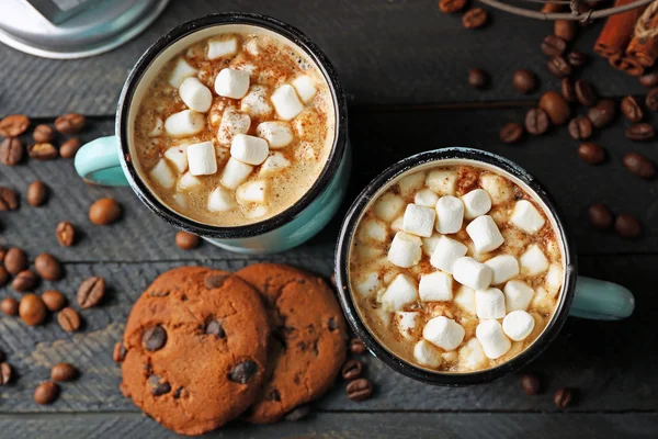 Zwei Becher heißen Kakao mit Marshmallow und Keksen auf schwarzem Tisch — Stockfoto