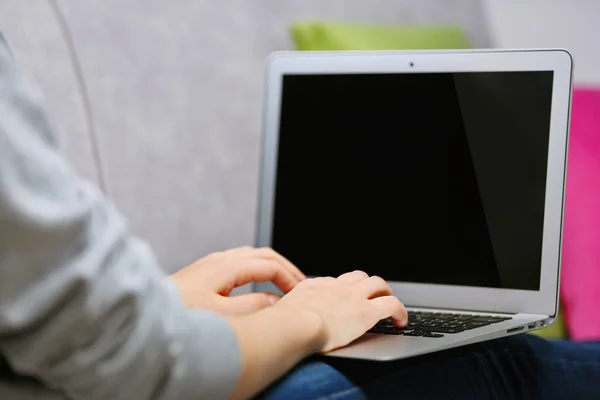 Mulher sentada no sofá com laptop — Fotografia de Stock