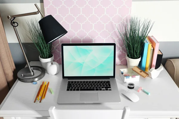 Рабочее место со столом, лампой и ноутбуком в гостиной — стоковое фото