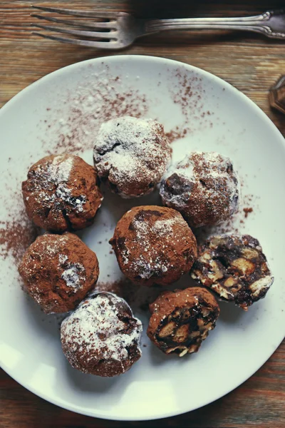 Boules de chocolat sur une assiette sur fond en bois — Photo