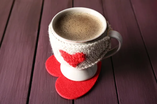 Xícara de café com leite em um coração de suporte em fundo de madeira closeup — Fotografia de Stock