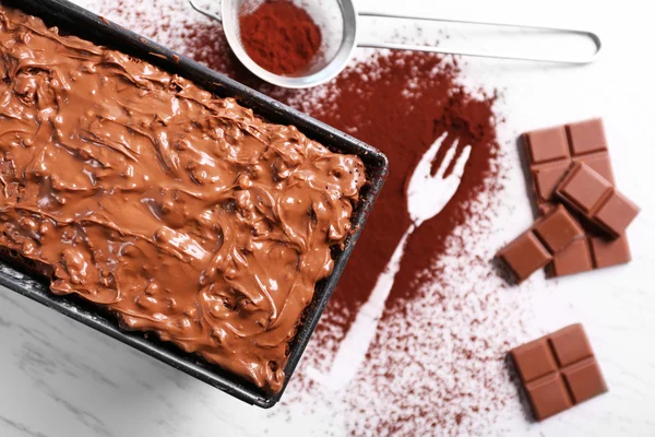 Вкусный торт в сковороде, украшенной шоколадом и кокосом на белом деревянном столе, крупным планом — стоковое фото