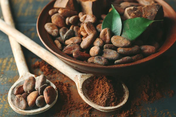 Cuchara con cacao aromático en polvo y hoja verde, de cerca — Foto de Stock